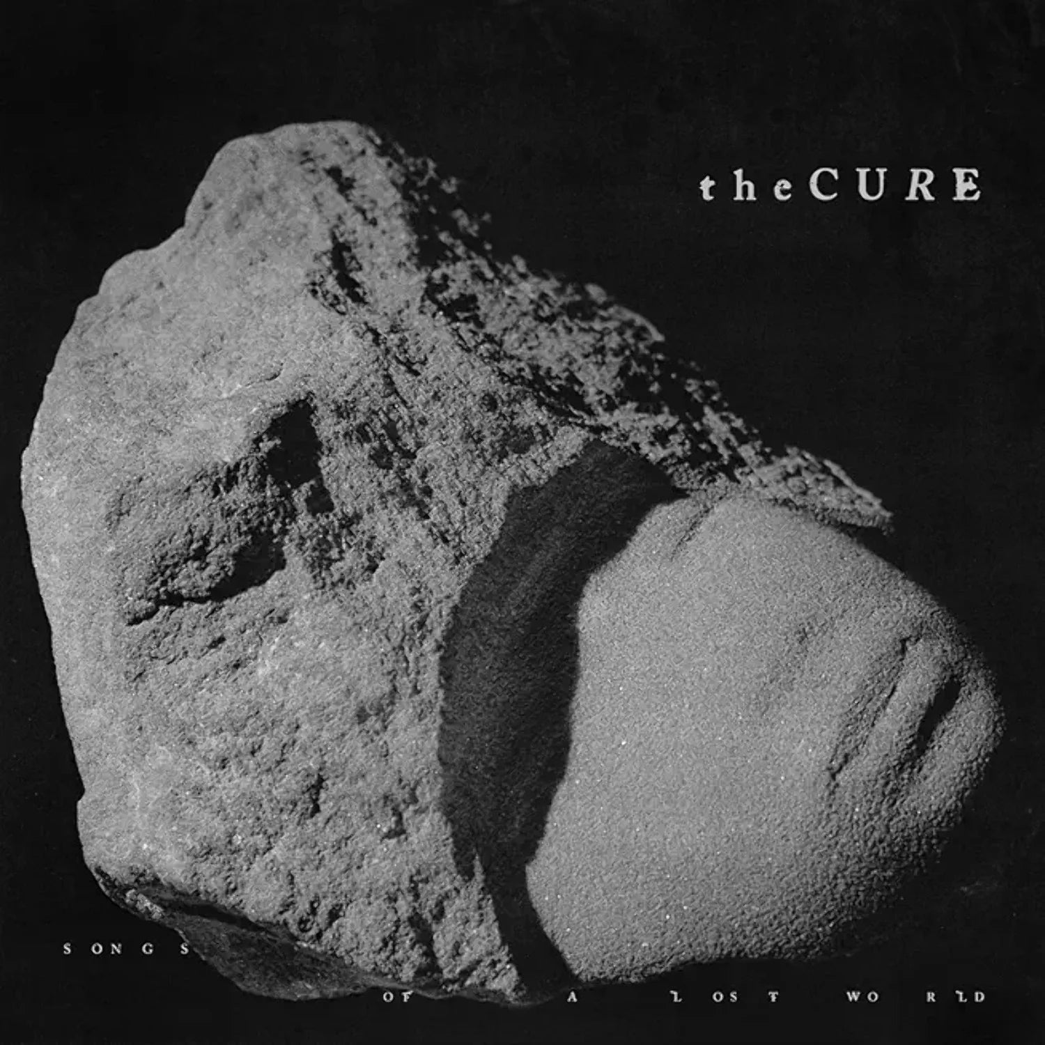 Album cover with a rock and 'the CURE' text on a dark background